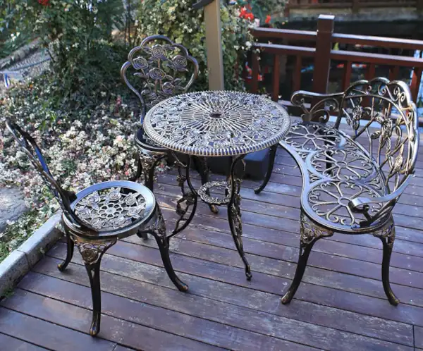 What is the Difference Between Cast Iron and Cast Aluminum 01 - metal bronze bistro set and metal bench on porch